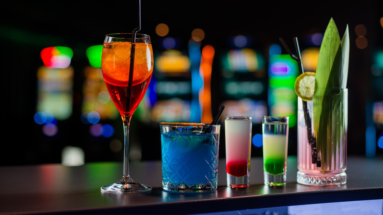 A variety of high end cocktails sit on a bar