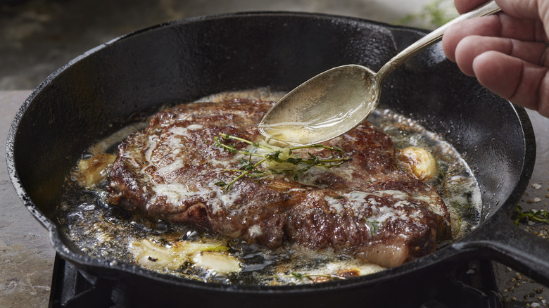 ribeye in pan basted in butter pan sauce