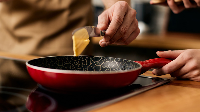 Home cooks adding butter to pan