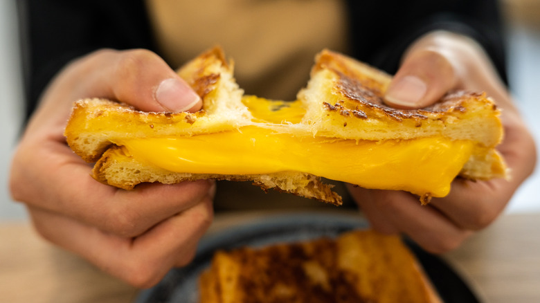 A close up photo of a stretchy and melty grilled cheese