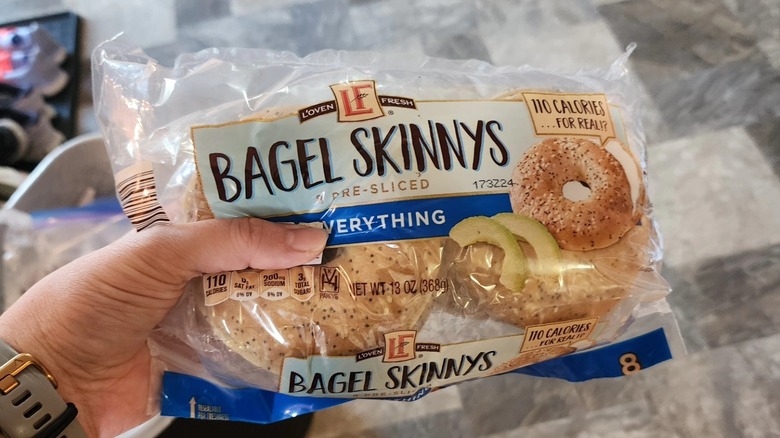 A hand holds a bag of bagel skinnys from Aldi
