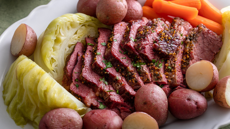 Corned beef nestled amongst cabbage, potatoes, and carrots