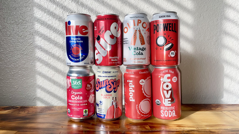 Several of prebiotic sodas stacked on a wooden surface.
