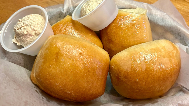 Texas Roadhouse rolls with cups of honey cinnamon butter.