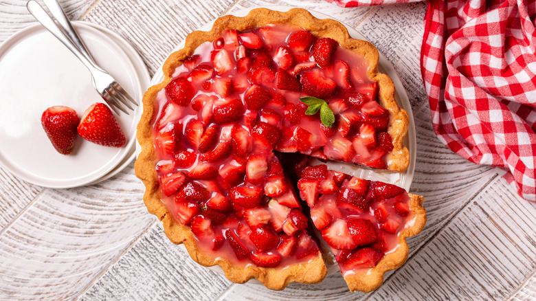 A strawberry pie with one piece cut out, but not removed