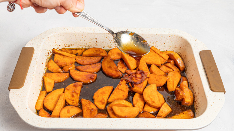 spooning spiced butter on yams