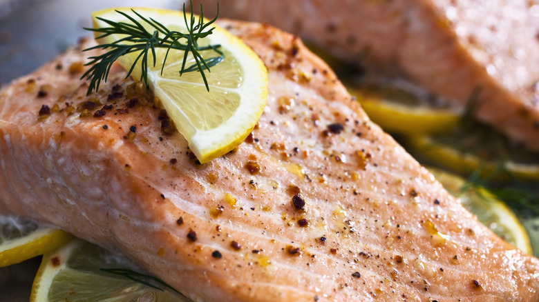 Baked salmon garnished with lemon and herbs.