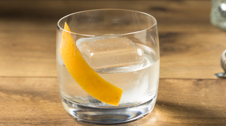 A white Negroni with orange peel