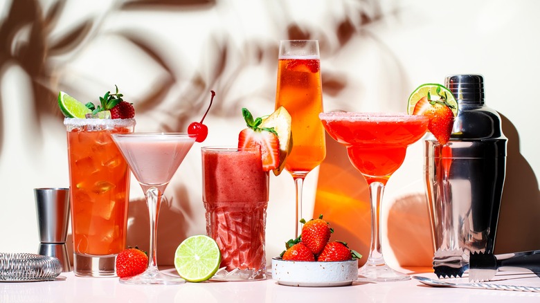 Array of red and orange cocktails with shaker