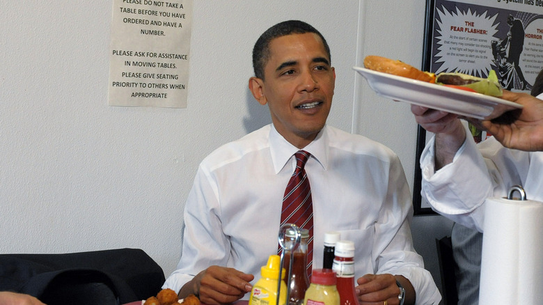 Obama being served a cheeseburger
