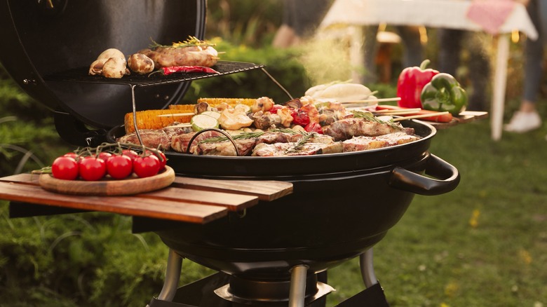 full barbecue grill with food sitting on lawn