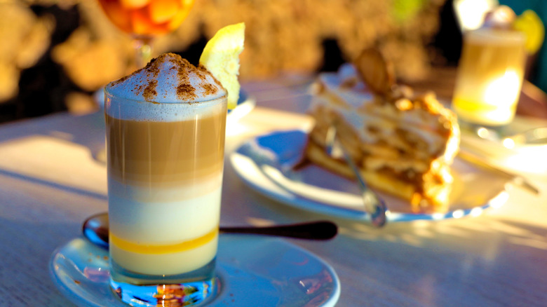 A barraquito cocktail with slice of cake