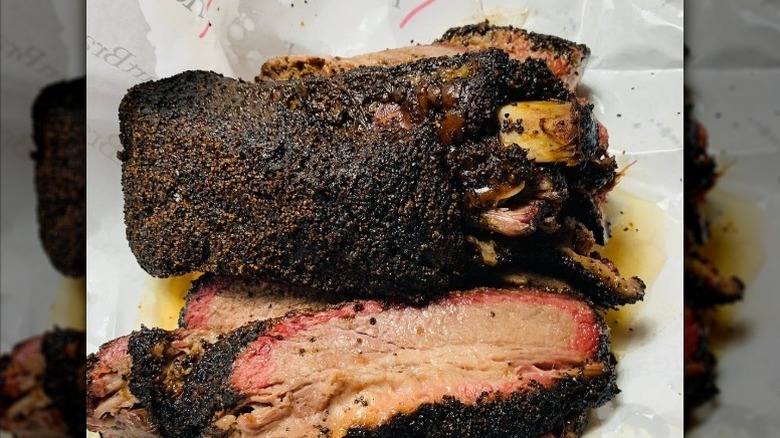 Large ribs and brisket rest on a paper liner at Cattleack Barbecue in Farmer's Branch, Texas