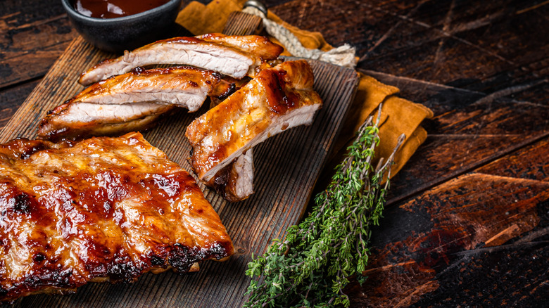 Grilled pork ribs with sauce next to herbs