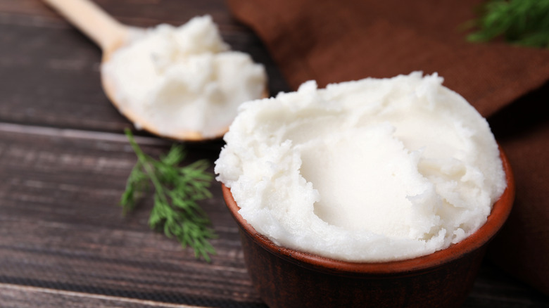 Lard in a small wooden bowl with a spoonful of lard