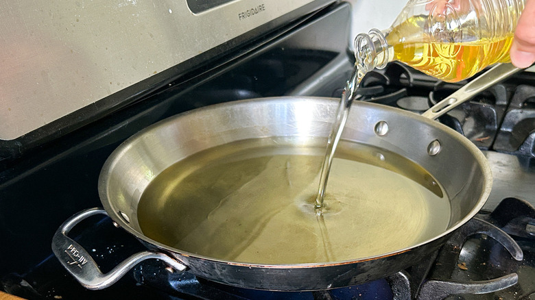 pouring oil into frying pan