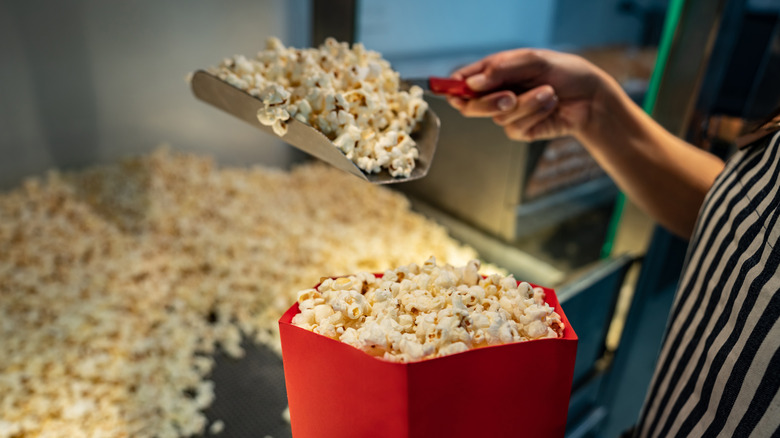 scooping movie theater popcorn into bucket