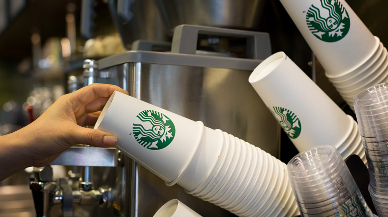 Hand reaching for disposable starbucks cup