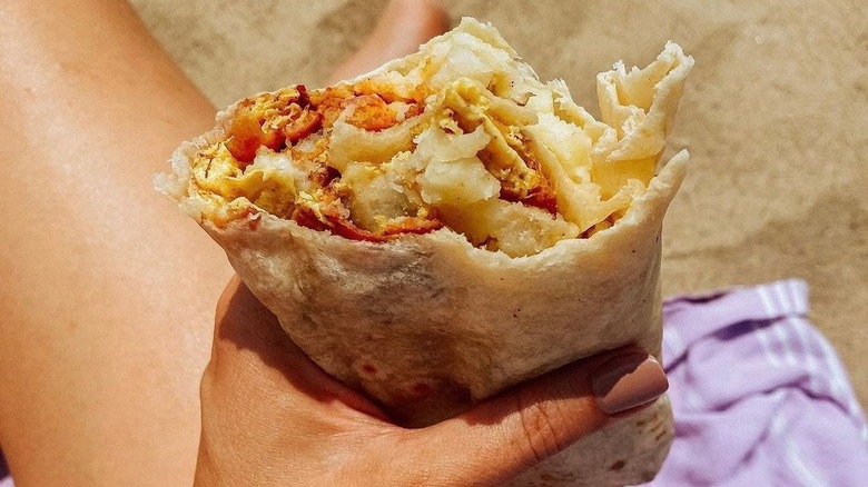 hand holding eaten burrito