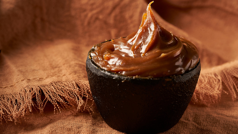 Cajeta in a small black bowl.