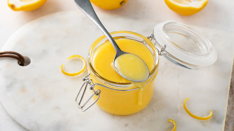 A spoonful and jar of lemon curd.