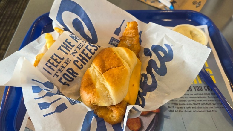 Culver's Northwoods Walleye Sandwich fillet hanging over the edge of the roll atop its tray