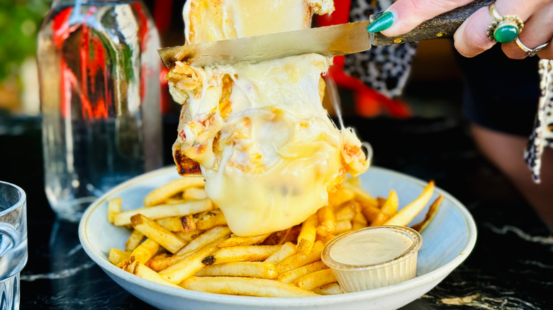 Cheese being slide onto fries at Craft & Commerce