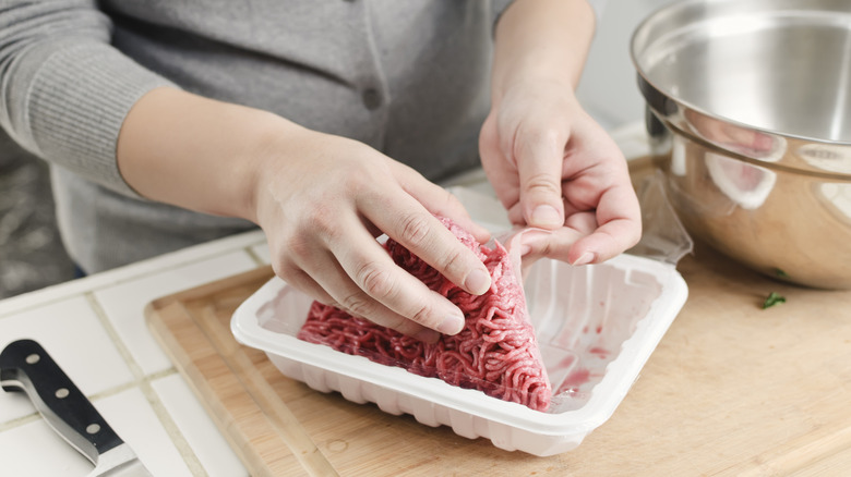 Person unpacking ground meat from container