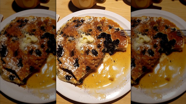 Blueberry pancakes on a white plate.