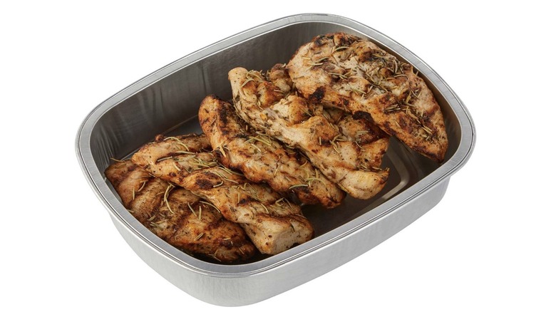 Tray of grilled chicken breasts seasoned with Italian herbs