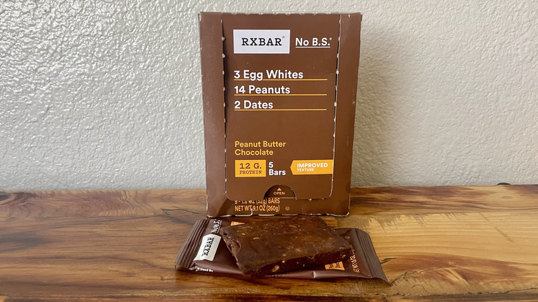 A box of Peanut Butter Chocolate RXBARs and an opened package with a bar on top of it.