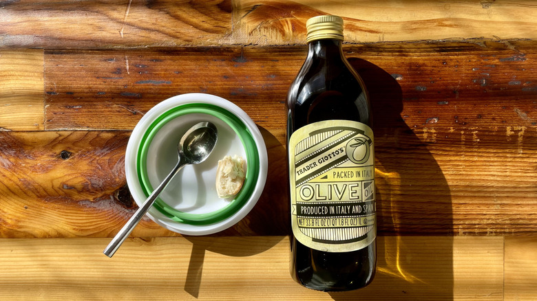 Bottle of Trader Giotto's Imported Olive Oil Packed In Italy on a wooden table