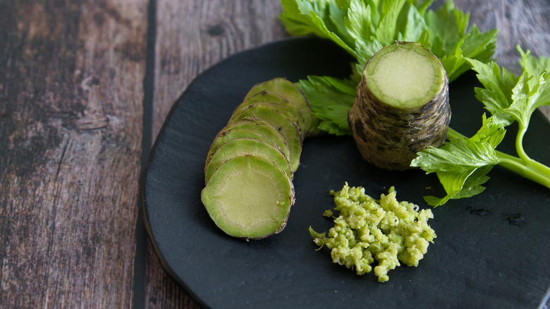 A plate has wasabi root and ground wasabi on it.