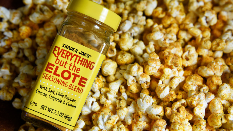 Trader Joe's Everything But The Elote bottle above elote-flavored popcorn