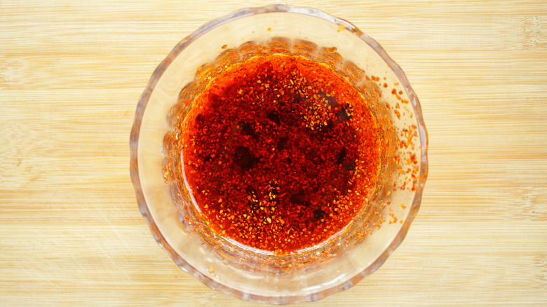 Overhead view of a glass bowl full of chili oil