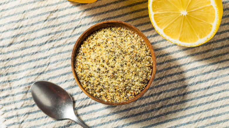 Fresh lemon and a bowl of lemon pepper seen from above