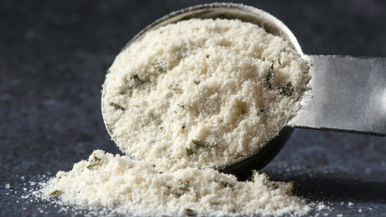 Metal measuring spoon full of ranch seasoning with some spilling out