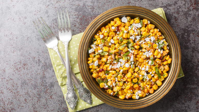 Corn kernels and cheese in a brown bowl