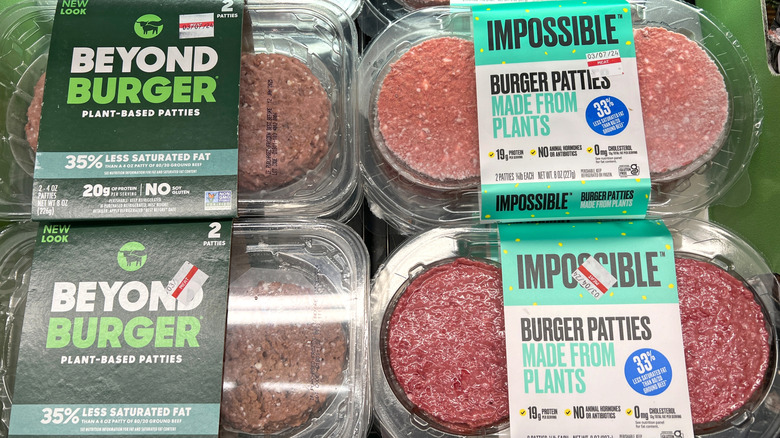 Side-by-side packages of Beyond Meat burgers and Impossible burgers
