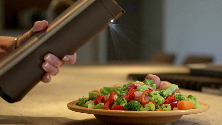 Biem butter sprayer over plate of veggies