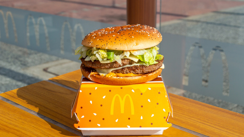 A Big Mac on a Big Mac box in front of a window