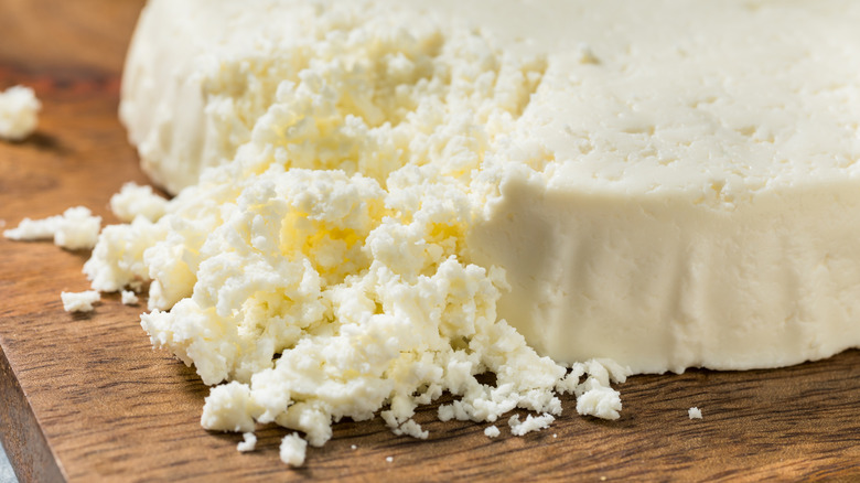 A wheel of crumbly white cheese