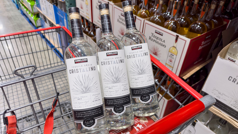 Three cristalino tequila bottles sit in a cart at Costco