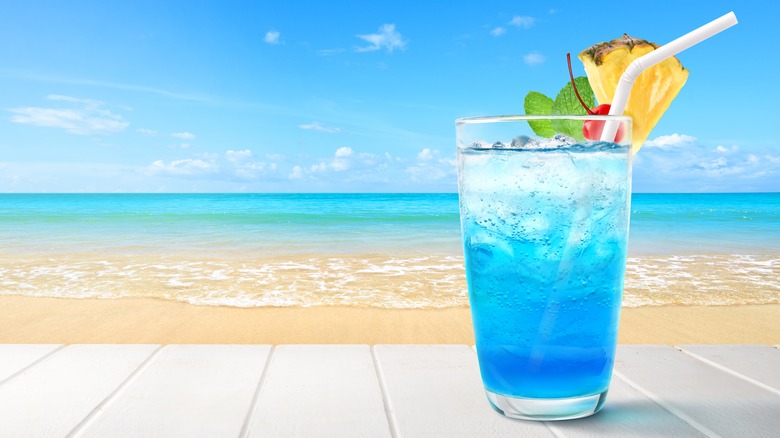 Blue Curaçao cocktail in front of beach