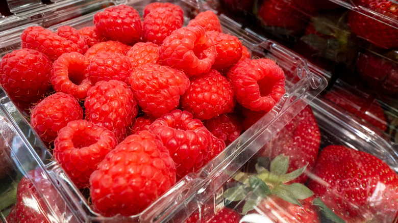 A plastic carton of raspberries.