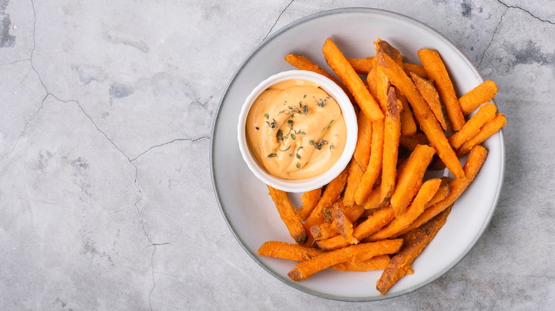 Orange colored sauce with sweet potato fries