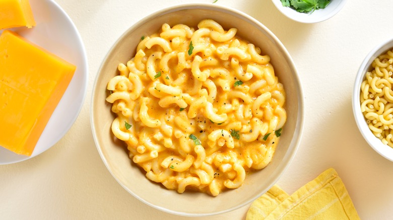 bowl of mac and cheese with pepper and herbs