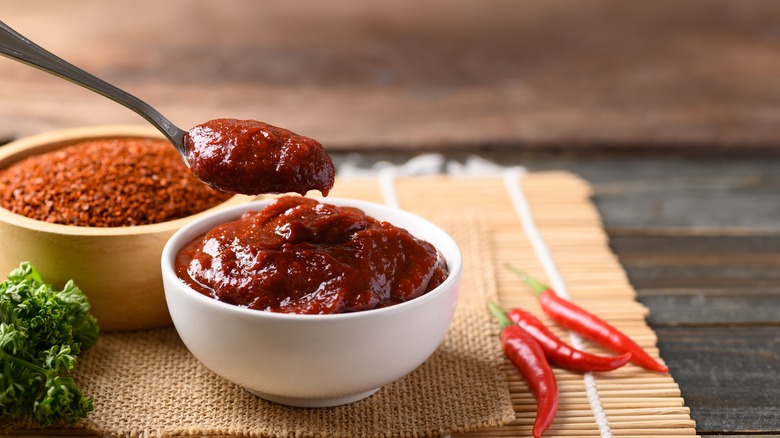 bowls of gochujang and red chile flakes on a bamboo mat