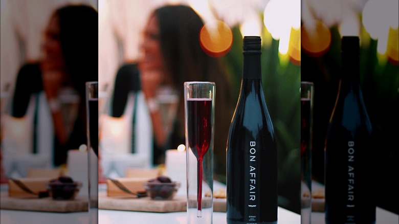 A bottle of Bon Affair with a glass of red wine seltzer