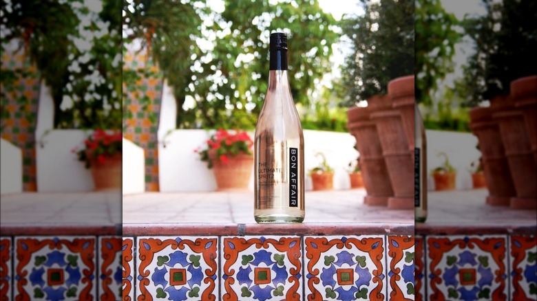 A bottle of Bon Affair on pool ledge